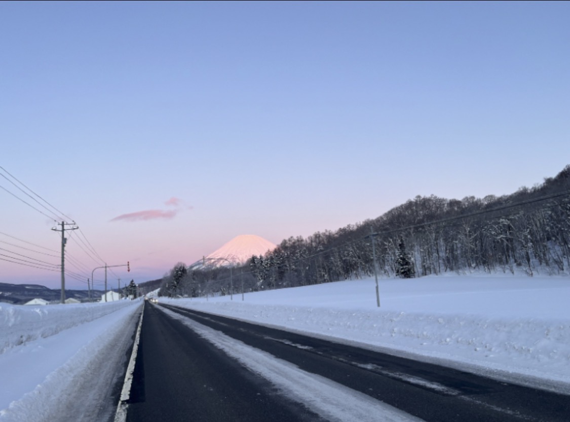 A snow-covered road with Mt. Yotei in view — a private taxi bound for destinations across Hokkaido from New Chitose Airport